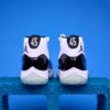 Air Jordan 11 High preto e branco, com couro envernizado brilhante, solado translúcido e o icônico logotipo Jumpman na lateral, visto de perfil