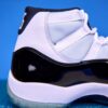 Air Jordan 11 High preto e branco, com couro envernizado brilhante, solado translúcido e o icônico logotipo Jumpman na lateral, visto de perfil