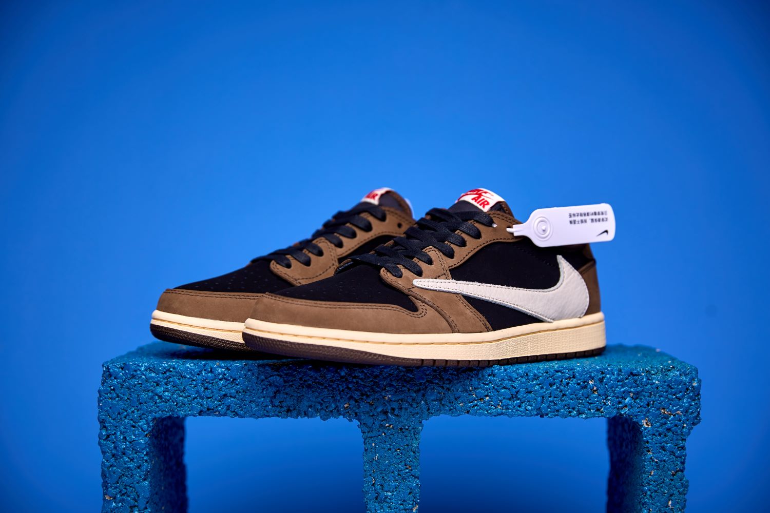 Air Jordan 1 Low preto e marrom visto de cima, destacando o design clássico, o Swoosh da Nike e o acabamento premium do cabedal