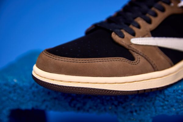 Air Jordan 1 Low preto e marrom visto de cima, destacando o design clássico, o Swoosh da Nike e o acabamento premium do cabedal