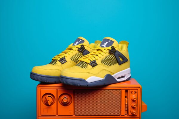 Nike Air Jordan 4, destacando os painéis laterais em mesh, a entressola robusta e os detalhes clássicos do modelo.