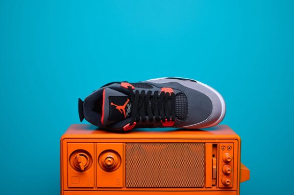 Nike Air Jordan 4, destacando os painéis laterais em mesh, a entressola robusta e os detalhes clássicos do modelo.