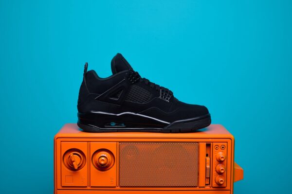 Nike Air Jordan 4, destacando os painéis laterais em mesh, a entressola robusta e os detalhes clássicos do modelo.