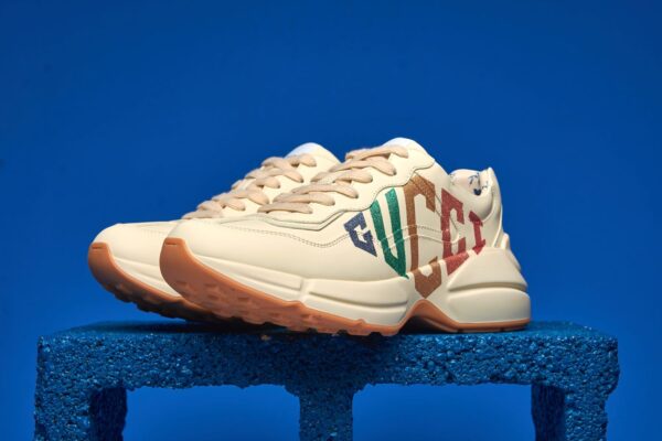 Tênis Gucci Rhyton com estampa de logo, em couro, com design robusto e moderno, combinando luxo e conforto para um visual elegante e ousado.
