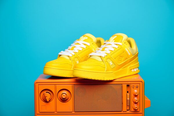 Tênis Louis Vuitton Trainer em couro premium, com design inspirado no basquete dos anos 80. Detalhes sofisticados, monograma LV e solado de borracha para máximo conforto.