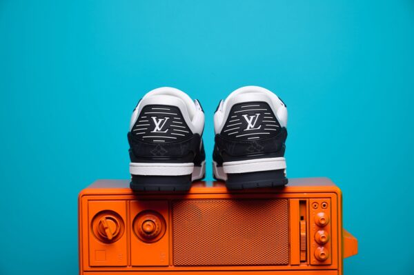 Tênis Louis Vuitton Trainer em couro premium, com design inspirado no basquete dos anos 80. Detalhes sofisticados, monograma LV e solado de borracha para máximo conforto.
