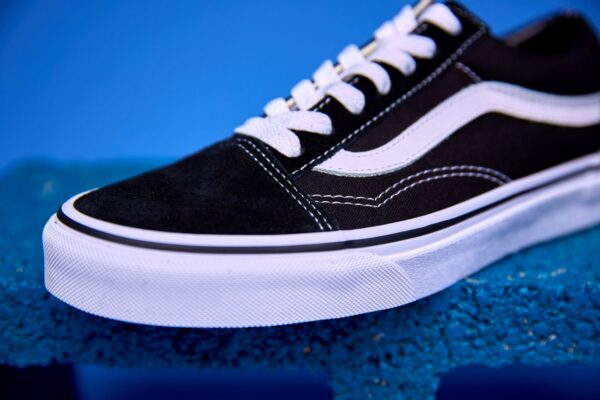 Tênis Vans Old Skool preto e branco, com a icônica faixa lateral e solado Waffle antiderrapante.
