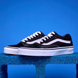 Tênis Vans Old Skool preto e branco, com a icônica faixa lateral e solado Waffle antiderrapante.
