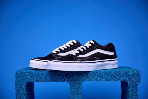 Tênis Vans Old Skool preto e branco, com a icônica faixa lateral e solado Waffle antiderrapante.