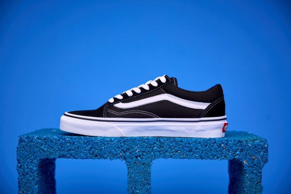 Tênis Vans Old Skool preto e branco, com a icônica faixa lateral e solado Waffle antiderrapante.